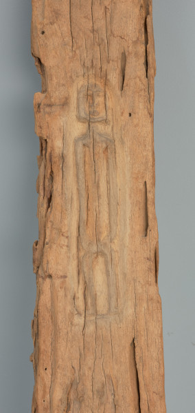 rzeźba - Ujęcie detalu. Długa, pionowa maska, wyrzeźbiona w drewnie.