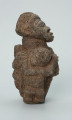 rzeźba; przedmiot obrzędowy; figura kultu zmarłych - Ujęcie prawy bok. Rzeźbiona w ziemistym steatycie siedząca postać ludzka o cechach kobiecych, otoczona przez trójkę mniejszych, dzieciecych postaci, skierowanych ku niej z uniesionymi rękoma.