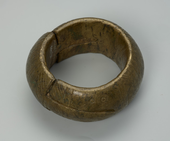 biżuteria, bransoleta - Ujęcie z tyłu z góry. Dwuczęściowa, mosiężna, kulista bransoleta składająca się z dwóch wkładanych, półkulistych elementów. Zewnętrzna powierzchnia ozdobiona punktowym wzorem w postaci pionowych i ukośnych linii, kół oraz półkoli. Brak wzoru na bocznym grzebiecie.