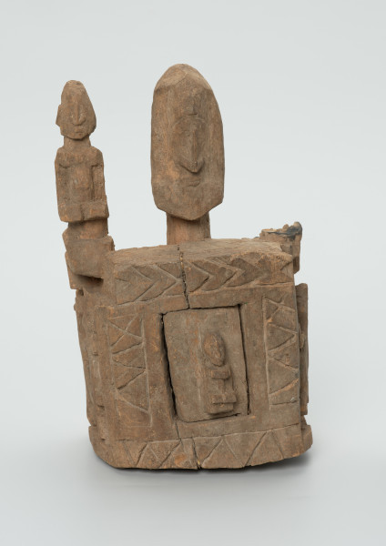 drewniane pudełko na fetysz - Ujęcie z przodu. Drewniane pudełko, dekorowane płaskorzeźbami, w środku którego widoczne są drzwiczki.