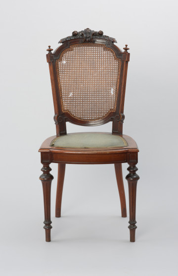 krzesło - Ujęcie z przodu. Tapicerowane krzesło płasko wyściełanym siedziskiem i plecionym oparciem