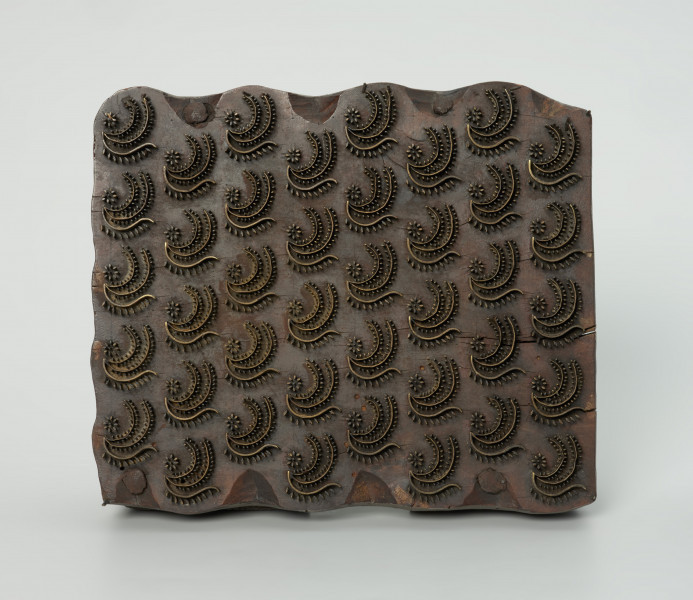 sprzęt do drukowania i grafiki, matryca drukująca - Ujęcie z przodu. Matryca do drukowania tkanin z wykonanym z nabitych w drewno mosiężnych sztyfcików i blaszek ornamentem o motywie roślinnym.