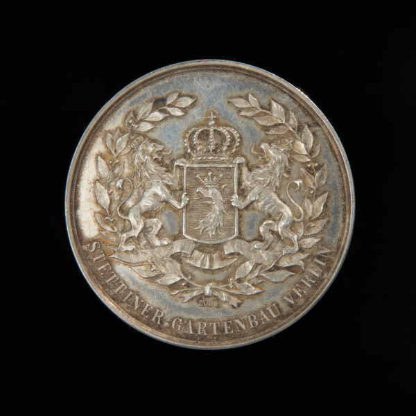 medal nagrodowy - Ujęcie awersu. Na awersie w wieńcu laurowym przewiązanym u dołu wstążką ukoronowany herb Szczecina podtrzymywany przez dwa wspięte lwy. Pod wstążką sygnatura. U dołu w otoku napis.