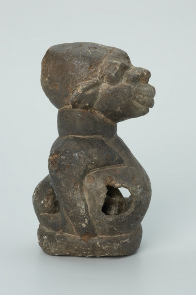 rzeźba; przedmiot obrzędowy; Figura kultu sił wegetacji - Ujęcie prawy bok. Rzeźbiona w grafitowym steatycie półpostać o cechach ciężarnej kobiety. W dużym, wydętym brzuchu z czterema otworami umieszczona jest kamienna kula.
