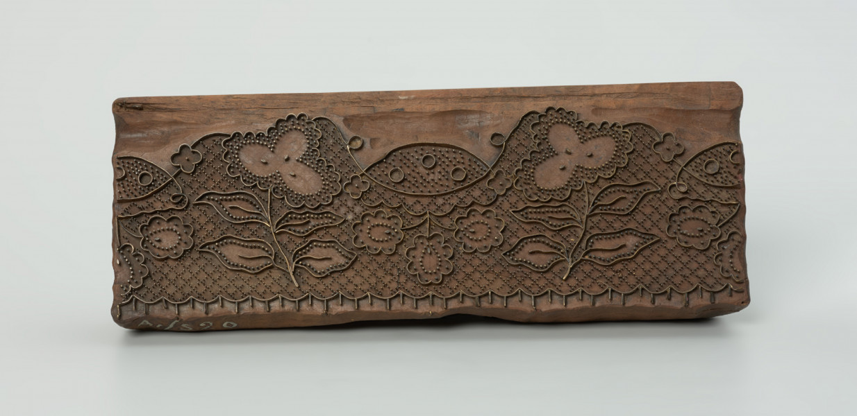 sprzęt do drukowania i grafiki, matryca drukująca - Ujęcie z przodu. Matryca do drukowania tkanin z wykonanym z nabitych w drewno mosiężnych sztyfcików i blaszek ornamentem naśladującym koronkę siatkową.