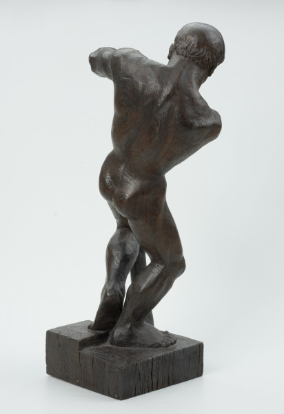 akt męski - Ujęcie z tyłu skosem w lewą stronę; Akt męski ujęty w kontrapoście. Tors odchylony w lewo, wyciągnięte w prawo ręce obejmują wygiętą w łuk belkę, wspartą drugim końcem na postumencie. Stopy złączone, kolana przygięte, rozchylone, jedno z kolan napiera na belkę. Krągła głowa pochylona w dół, włosy krótkie, przylegające do czaszki.