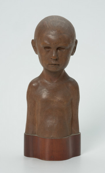 portret dziecięcy - Ujęcie z przodu; Wyrzeźbione w drzewie mahoniowym popiersie dziecka, chłopczyka. Ogolona głowa, oczy blisko siebie, smutne usta. Przedstawiony jest kilkuletni syn artysty.