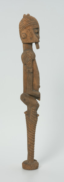 drewniana, rzeźbiona figura - Ujęcie z prawego boku. Drewniana, rzeźbiona postać człowieka na szczudłach.