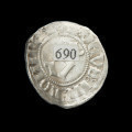 Srebrna moneta pomorska witen - Ujęcie z tyłu. Cienka moneta okrągła, o nieregularnych kształtach; napis po zewnętrznej stronie; brzeg wewnętrzny zaznaczony perełkowatym wzorem; w środku okrąg z gotycką literą 