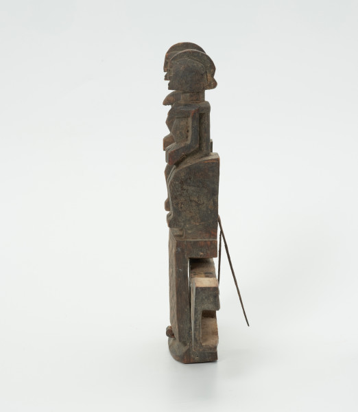 drewniany zamek do drzwi - Ujęcie z boku. Drewniany zamek do drzwi, z wyrzeźbionymi dwoma postaciami człowieka oraz z dekoracją w formie ornamentu.