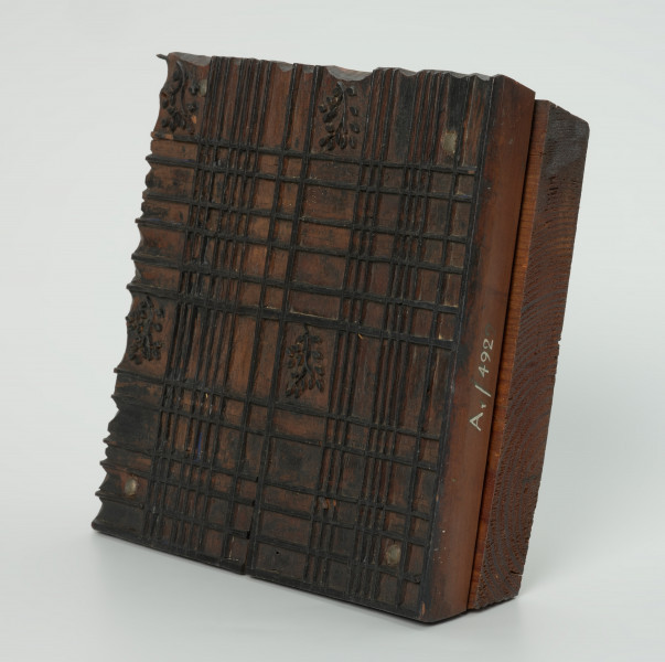 sprzęt do drukowania i grafiki, matryca drukująca - Ujęcie przodu skosem w prawą stronę. Matryca do drukowania tkanin z wykonanym w drewnie ornamentem geometryczno - roślinnym.