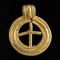 Zawieszka pierścieniowata - Ujęcie z tyłu. Złota zawieszka pierścieniowata wykonana z trzech koncentrycznych pierścieni ze złotego drutu. Pierścień zewnętrzny i wewnętrzny jest pokryty gęstym, perełkowatym karbowaniem. Pierścień środkowy jest niezdobiony. Wnętrze zawieszki wypełnia perełkowaty drucikowaty krzyżyk. Zawieszka posiada uszko ze złotej blaszki.