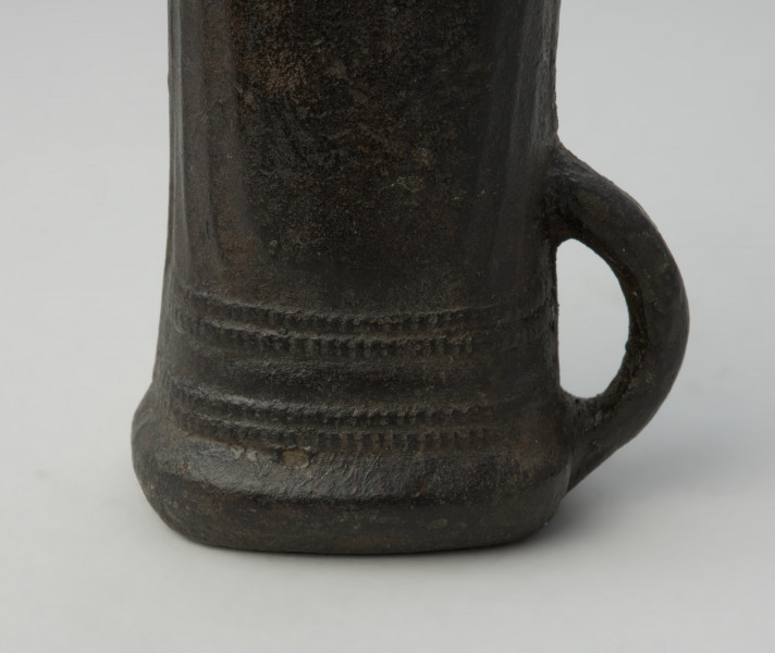 topór, siekiera - Ujęcie detalu tulejki ze zdobieniami z prawej strony.  Siekierka brązowa z tulejką i dużym uszkiem, dekorowana żeberkowaniem i karbami przy wylocie tulejki.