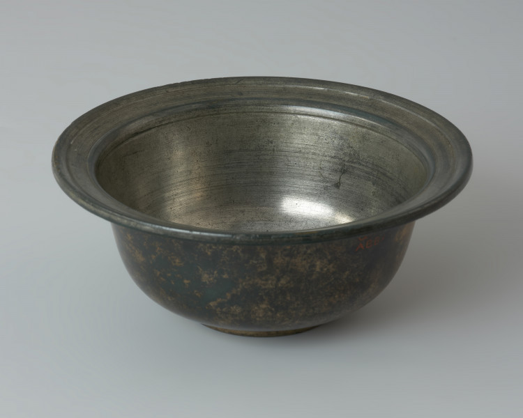 Rzymska miseczka z brązu na stopce - Ujęcie z przodu z góry. Rzymska miseczka z brązu na stopce z cylindrycznym brzuścem, szerokim wygiętym na zewnątrz wylewem, posrebrzana wewnątrz.