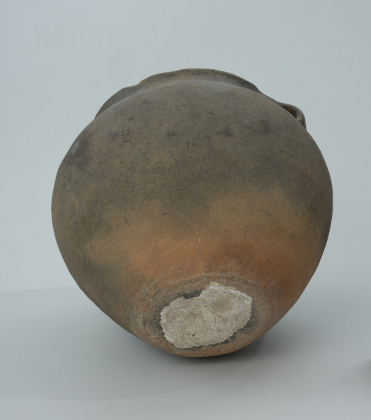 Ciemnobrunatna gliniana waza z dwoma uchami. - Ujęcie z dołu. Ciemnobrunatna gliniana waza z dwoma uchami