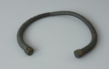 Ujęcie z tyłu. Naszyjnik z brązu zachowany w dwóch częściach.