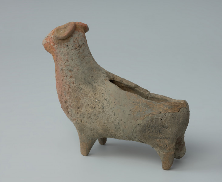 Ujęcie lewego boku. Gliniane naczynie przedstawiające postać barana.
