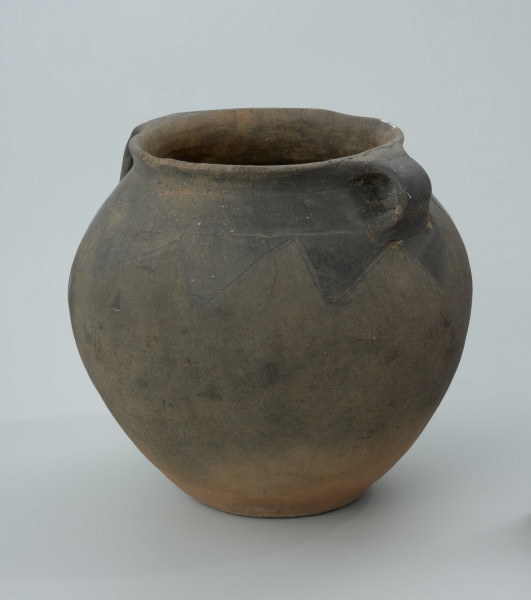 Ciemnobrunatna gliniana waza z dwoma uchami. - Ujęcie z boku. Ciemnobrunatna gliniana waza z dwoma uchami