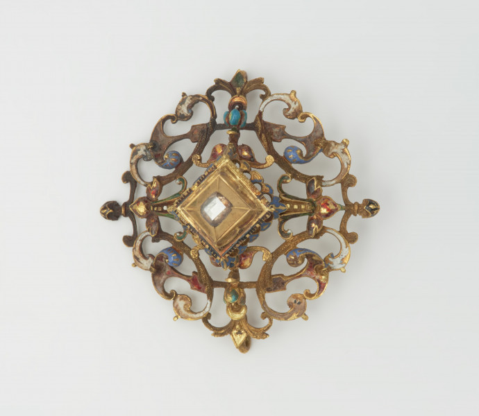 biżuteria, ozdoby - Ujęcie z przodu. Ażurowy klejnot z kołpaka z diamentem, zdobiony barwną emalią.