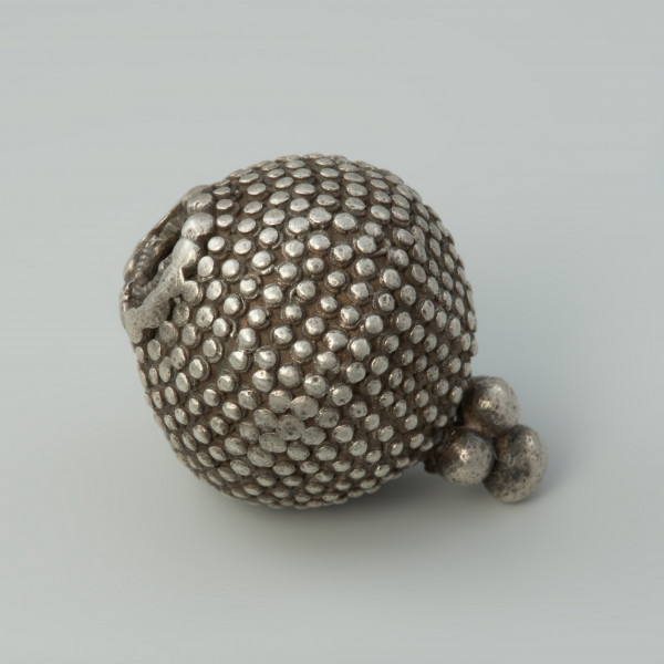 guz, biżuteria, ozdoba - Ujęcie lewej strony w poziomie. Guz srebrny okrągłego kształtu zdobiony granulacją.