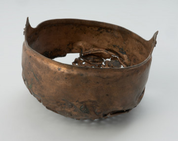 Cedzak ze stopu miedzi - Ujęcie z przodu. Cedzak ze stopu miedzi o owalnym kształcie z dwoma trójkątnymi uchami.