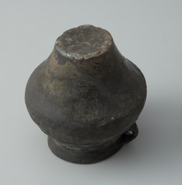 Dwuuche naczynie - Ujęcie z dołu. Dwuuche naczynie o gładkiej powierzchni barwy ciemnobrunatnej, miejscami czarnej.