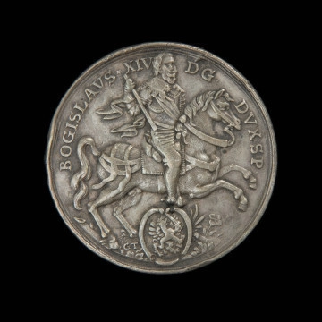 MNS/N/15881 dwutalar medalowy - Ujęcie awersu. Na awersie książę w zbroi z pałką w prawej dłoni na rozpędzonym koniu w prawo. Poniżej w tarczy gryf z mieczem i Biblią w prawo. Z lewej strony tarczy inicjały GT. W otoku napis.