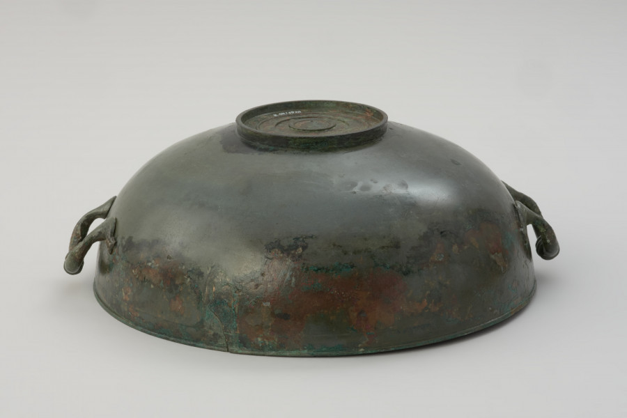 misa z brązu - Ujęcie spodu. Rzymska misa z brązu na stopce, zaopatrzona w parę przeciwstawnych uch z trzema guzami pośrodku.