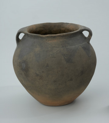 Ciemnobrunatna gliniana waza z dwoma uchami. - Ujęcie z przodu. Ciemnobrunatna gliniana waza z dwoma uchami