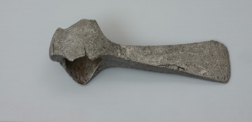 topór bojowy (czekan) - Ujęcie z góry w poziomie. Topór ma smukłe żeleźce, prawie prostopadłe w stosunku do osi pionowej toporzyska. Światło osady jest owalne, a sama osada ma zdecydowanie wyodrębnione, nieznacznie zaokrąglone i opuszczone w dół wypustki zwane wąsami. Obuch jest zakończony krótkim, prostokątnym w przekroju zgrubieniem, tzw. młotkiem. Żeleźce topora ma smukłą szyjkę, która łagodnie rozszerza się tworząc wąskie, lekko asymetryczne i łukowate ostrze.