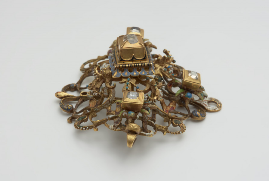 nakrycia głowy, biżuteria, ozdoby - Ujęcie z boku od góry. Klejnot z kołpaka w kształcie rombu, ażurowy, zdobiony emalią i kasztami z diamentami.