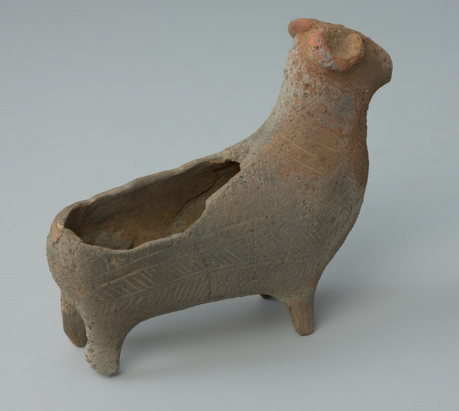 Ujęcie z tyłu. Gliniane naczynie przedstawiające postać barana.