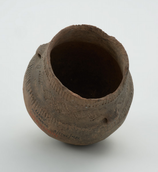 naczynie - ujęcie z dołu; Amfora z baniastym brzuścem, prawie cylindryczną szyjką i parą taśmowatych uch umieszczonych niesymetrycznie  u nasady szyjki, zdobiona pod wylewem dookolnymi pasmami pionowych słupków odciskanych, na szyjce stemplami tworzącymi zygzaki i pomiędzy nimi rytymi rombami wypełnionymi ukośną kratką, a na górze brzuśca ponownie dookolnym pasmem pionowych słupków odciskanych