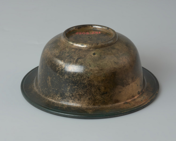 Rzymska miseczka z brązu na stopce - Ujęcie z przodu z dołu. Rzymska miseczka z brązu na stopce z cylindrycznym brzuścem, szerokim wygiętym na zewnątrz wylewem, posrebrzana wewnątrz.