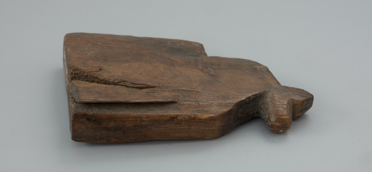 przedmiot kultowy, figurka - Ujęcie lewej strony w poziomie. Figurka drewniana przedstawiająca konia z realistycznie zaznaczonym łbem i szyją.