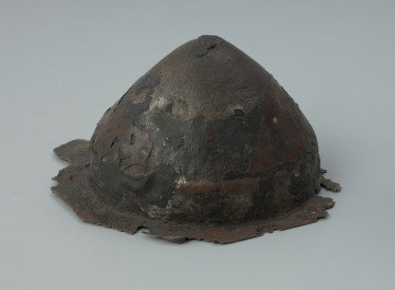 Żelazne umbo ze zniszczonym brzegiem. - Ujęcie z prawej strony. Żelazne umbo ze zniszczonym brzegiem.