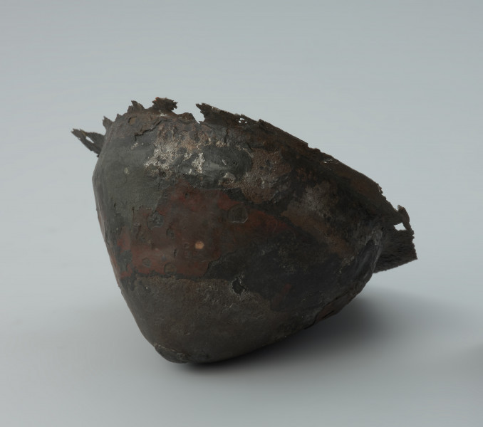 Żelazne umbo ze zniszczonym brzegiem. - Ujęcie z prawej strony odwrócone. Żelazne umbo ze zniszczonym brzegiem.