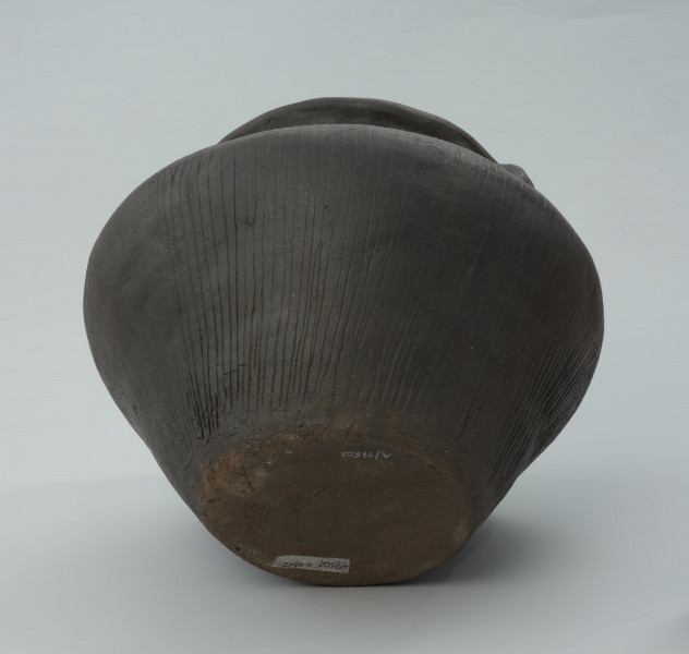 Waza gliniana barwy ciemnobrunatnej, wygładzana na powierzchni z uchem - Ujęcie z dołu. Waza gliniana barwy ciemnobrunatnej, wygładzana na powierzchni z uchem, które przechodzi w dookolne listwy plastyczne.