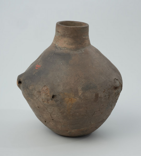 Naczynie gliniane - Ujęcie prawego boku; Amfora, zapewne o cylindrycznej szyjce (rekonstrukcja) i dwustożkowatym brzuścu, z pięcioma uchami na załomie, nie posiada żadnych zdobień.