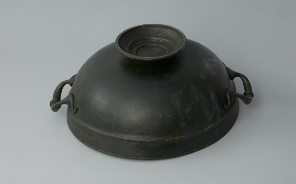 naczynie; Misa z brązu - Ujęcie z dołu. Misa z brązu na żebrowanej stopce. Na brzuścu znajduje się nieznacznie wypukły wałek.