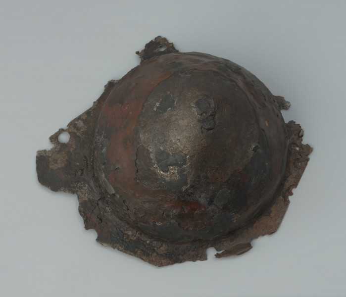 Żelazne umbo ze zniszczonym brzegiem. - Ujęcie z góry. Żelazne umbo ze zniszczonym brzegiem.
