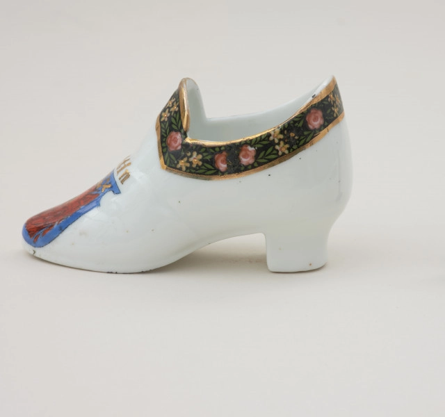 porcelanowy bucik ozdobiony malowanym szlaczkiem - Ujęcie prawej strony. Porcelonowy bucik ozdobiony malowanym szlaczkiem.