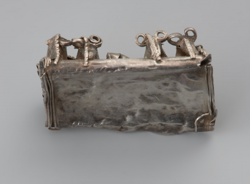 ozdoba - Ujęcie tyłu kaptorgi z góry. Kaptorga prostokątna zdobiona filigranem i motywem zoomorficznym.