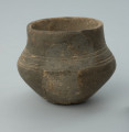 Jasnobrunatne naczynie gliniane o niskiej, przysadzistej formie - Ujęcie z przodu z prawej strony. Jasnobrunatne naczynie gliniane o niskiej, przysadzistej formie.