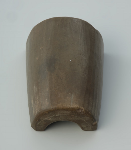 Forma odlewnicza - Ujęcie w pionie tylnej części wąskim elementem w dół.  Jedna część dwudzielnej, kamiennej formy odlewniczej z wizerunkami brodatych twarzy. Wykonano ją ze steatytu zwanego też słoninowcem lub kamieniem mydlanym, który jest miękki i łatwy w obróbce. Zdaniem odkrywców służyć miała do odlewania haczyków do wędek i ciężarków do sieci. Dzisiaj najczęściej uważa się, że jest to forma do odlewu uchwytów niewielkich zawieszek, tzw. osełkowatych lub dzwoneczków. Uwagę zwracają przede wszystkim zróżnicowane wielkościowo wyobrażenia męskich twarzy o migdałowatym kształcie, z dużymi oczami i obfitym zarostem. Po wykonaniu odlewu uzyskiwano przedmiot z wizerunkiem czterech twarzy, uważany za okucie niewielkiej osełki. Forma jest starannie wykonana i nie ma żadnych śladów użytkowania.