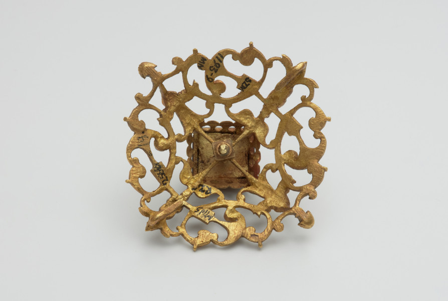 biżuteria, ozdoby - Ujęcie z tyłu. Ażurowy klejnot z kołpaka z diamentem, zdobiony barwną emalią.