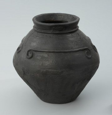 Ujęcie z przodu skosem w lewą stronę. Czarna wyświecana gliniana waza