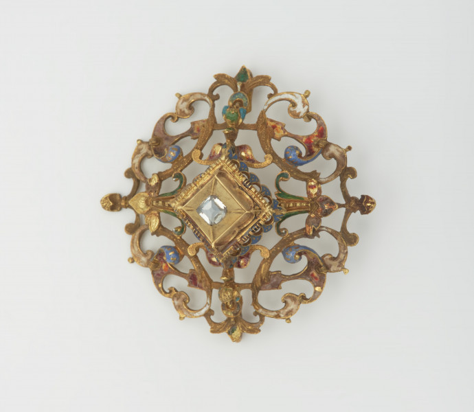 biżuteria, ozdoby - Ujęcie z przodu. Ażurowy klejnot z kołpaka z diamentem, zdobiony barwną emalią.