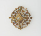 biżuteria, ozdoby - Ujęcie z przodu. Ażurowy klejnot z kołpaka z diamentem, zdobiony barwną emalią.