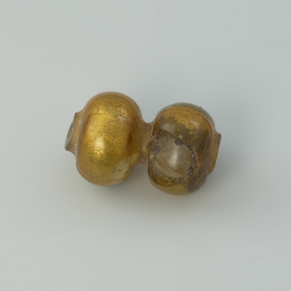 paciorek , biżuteria - Ujęcie lewej strony paciorka. Paciorek szklany dwusegmentowy zdobiony złotą folią.